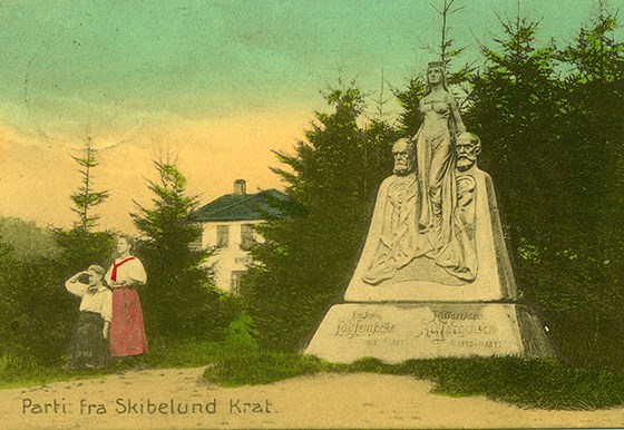 Symbolladet postkort fra Skibelund Krat 1910 med Modersmålet og to kvinder, der spejder mod syd ned mod Sønderjylland - den ene klædt i rødt og hvidt.